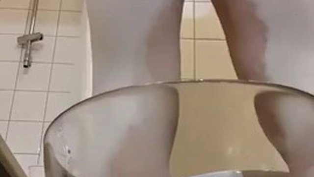 Travestito che piscia in leggings bianchi