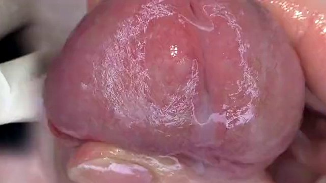 Super close-up of the glans. Urethral games with a dilator