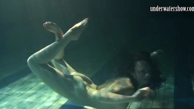 Irina Polcharova, vyholená brunetka, nahá v bazénu.